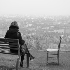 une femme assise seule sur un banc à coté d'une chaise vide. Un sentiment de solitude et de désespoir. Une femme célibataire attendant l'amour. Le célibat
