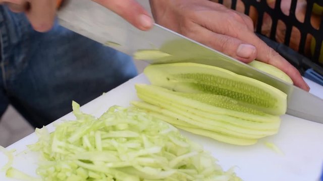 chef cook chopping cucumber. close up
