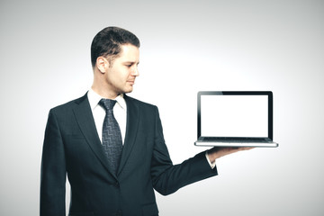 businessman in suit holding laptop