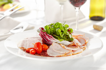 Gourmet, restaurant, delicious dinner food - close up of Sliced Meats with Rocket Salad and Tomatoes