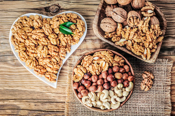 Wanluts in bowl. Walnuts heart on rustic wooden table. Mix nuts concept.