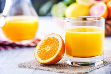 Orange juice in jar. Tropical fruits juice in glass with orange, lime and grep.