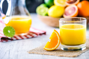 Orange juice in jar. Tropical fruits juice in glass with orange, lime and grep.
