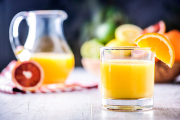 Fresh orange juice nectar in jar. Tropical fruits juice in glass with orange, lime and grep.