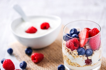 yogurt with forest fruits in white porcelain bowl. Yogurt with raspberries and blueberries.
