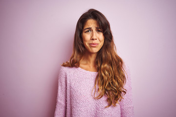 Fototapeta premium Young beautiful woman wearing sweater standing over pink isolated background depressed and worry for distress, crying angry and afraid. Sad expression.