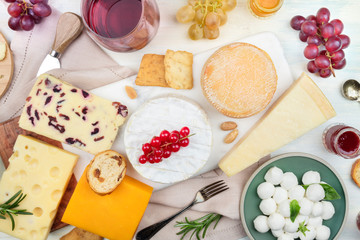 Wine and cheese platter, tasting and pairing. An assortment of various types of cheese and a glass of wine, shot from the top