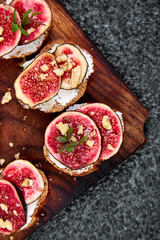 Fototapeta na wymiar Bruschetta or ctostini with cottage cheese, figs and honey. Sandwich with figs and goat cheese..