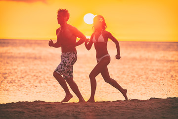 Running couple silhouettes athletes woman and man jogging together on beach training cardio...