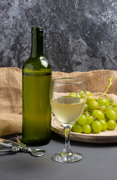 White wine glass with grapes in cellar atmosphere - image