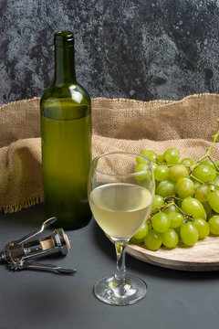 White wine glass with grapes in cellar atmosphere - image