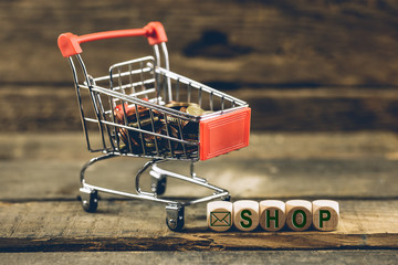 Warenkorb und Würfel für online Shop. Holz Struktur im Hintergrund