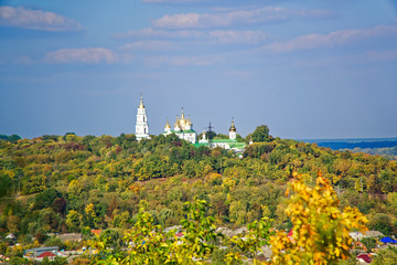 Fototapeta na wymiar Monastery caves - view from the banks of Vorskla River in early autumn