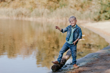 Portrait of cute smiling boy on a summer riverbank.