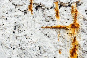 Natural background. A ground white wall with rusty pipes sticking out.