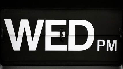 Close-up Flip clock label WED pm. on Black background, Time concept.