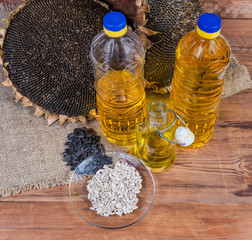 Top view of sunflower oil among sunflower heads and seeds