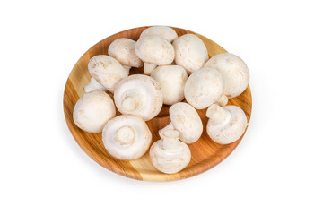 Cultivated button mushrooms on the wooden dish on white background