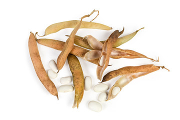 Partly husked kidney beans among dry pods on white background