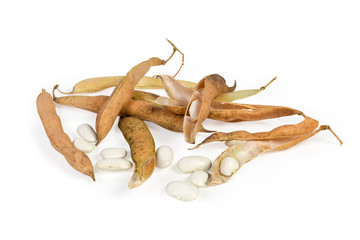 Partly husked kidney beans among dry pods on white background