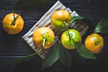 Tangerines with leaves on an old fashioned country table. Selective focus. Horizontal.