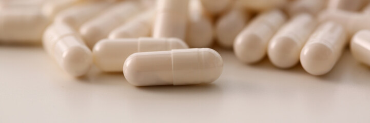 Tablets scattered white color on table of pharmaceutical laboratory pill for prescription and treatment various diseases chemistry background closeup