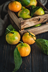Tangerines with leaves on an old fashioned country table. Selective focus. Vertical.