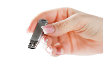 Woman hand holding silver usb in finger with beatiful nails. Flash drive holding in hand isolated.