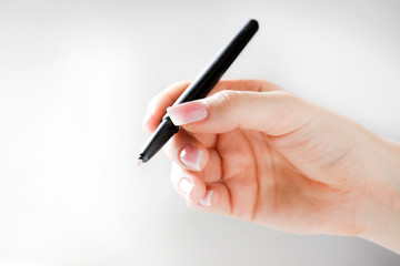 Woman hand holding black pen. Hand with pen isolated on white backround.