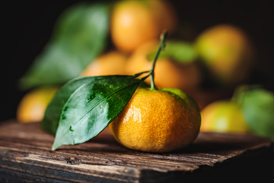 Tangerines with leaves on an old fashioned country table. Selective focus. Horizontal.