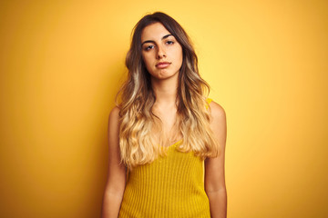 Fototapeta premium Young beautiful woman wearing t-shirt over yellow isolated background looking sleepy and tired, exhausted for fatigue and hangover, lazy eyes in the morning.