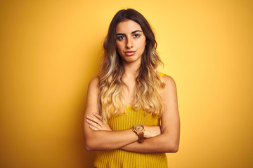 Young beautiful woman wearing t-shirt over yellow isolated background skeptic and nervous,...