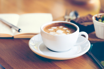 cup of coffee in a white cup on wooden background, coffee shop