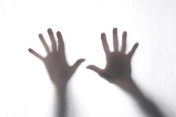 shadow or silhouette of two man's hands touching a white fabric from behind  in transparncy with copy space for your text