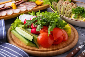 Assorted fresh vegetables on a wooden board.
