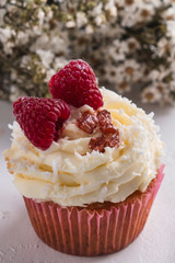 Cupcake with raspberry and coconut flakes. Raffaello cupcake. Closeup