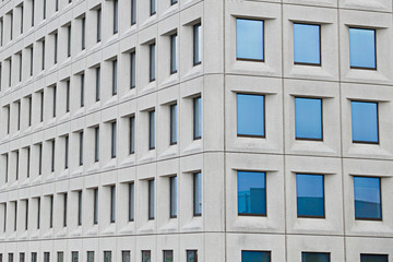 Several windows, with the sky reflected, in a modern building.