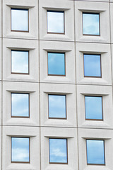 Several windows, with the sky reflected, in a modern building