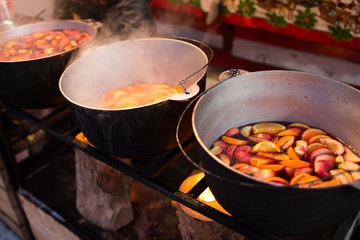 Hot gluhwein or mulled wine in a cauldron at fair, local treat, warm and spicy. A hot wholesome...