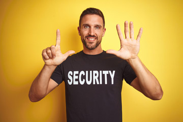 Young safeguard man wearing security uniform over yellow isolated background showing and pointing...