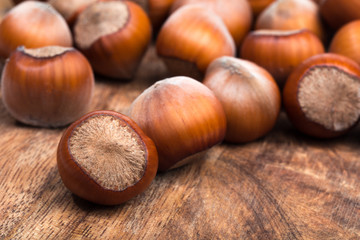 close up of hazelnuts on wooden table .