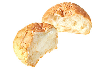 Two halves of broken tasty soft fresh round bun with sesame seeds for hamburger, cheeseburger or cooking other burgers. Isolated on white background. Close-up