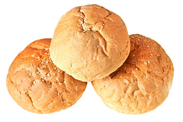 Heap of tasty soft fresh whole round buns with sesame seeds for hamburger, cheeseburger or cooking other burgers. Isolated on white background. Close-up