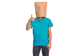Portrait of teen boy with paper bag over head making thumb up gesture, isolated on white...