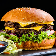 Fresh homemade burger with grilled potatoes, served with ketchup sauce