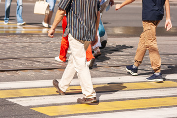 legs of pedestrians walking on the crosswalk