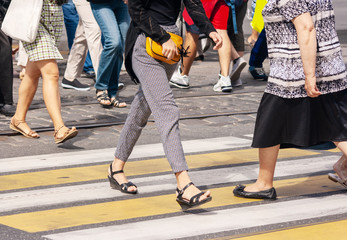 legs of pedestrians walking on the crosswalk