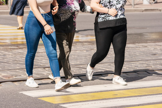 Legs Of Young Pedestrians Walking On The Crosswalk