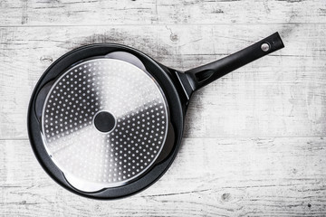 Induction frying pan for 4 pancakes. Balck pancakes pan on whiet old table. Empty new frying...