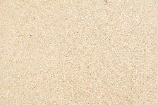 Closeup brown beige sheet of craft cardboard paper texture background.